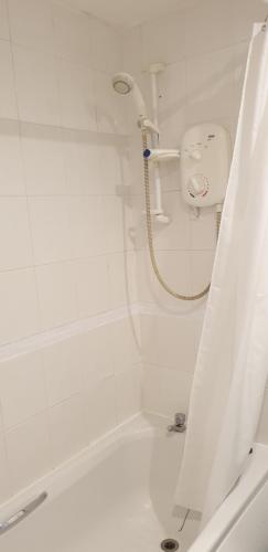 a white shower with a hose in a bathroom at Quarry street Hamilton in Hamilton