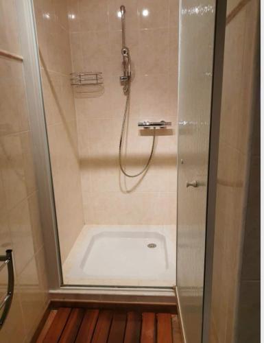 une douche avec une porte vitrée dans une salle de bain dans l'établissement La Petite Jeannette, à Lans-en-Vercors