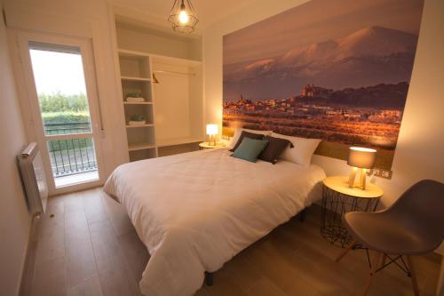 1 dormitorio con 1 cama con una pintura en la pared en CasaCascante, en Cascante