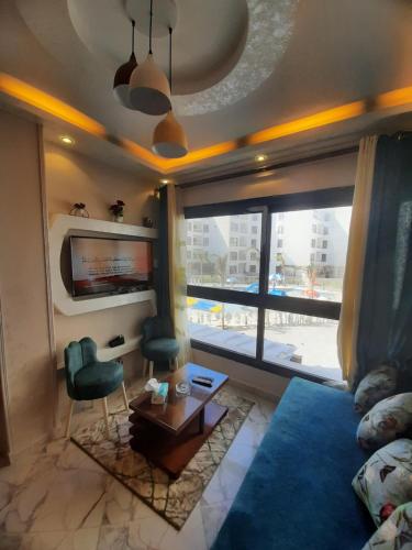 un salon avec un canapé bleu et une télévision dans l'établissement إستوديو فندقي بورتو سعيد porto said, à Port-Saïd