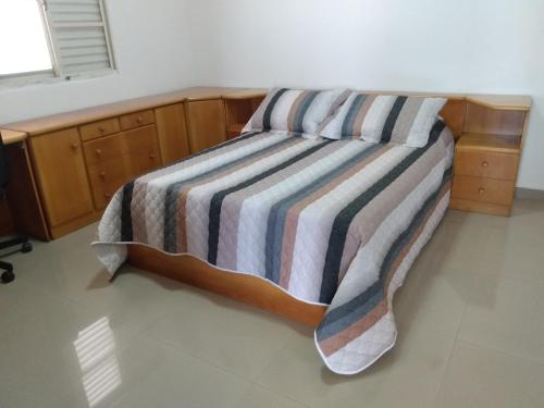a bed with a striped blanket on top of it at Casa Bela Vista in Penedo