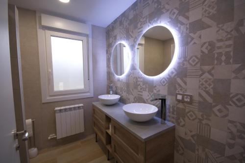 a bathroom with two sinks and a mirror at CasaCascante in Cascante