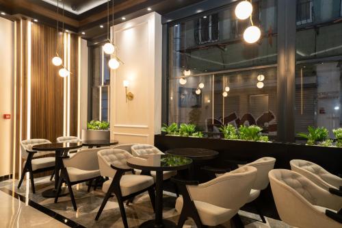 a restaurant with tables and chairs and plants at Fama Karaköy in Istanbul