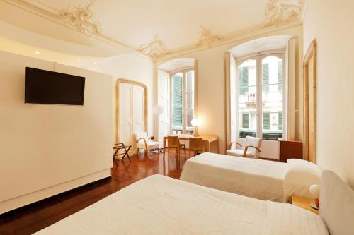 a hotel room with two beds and a flat screen tv at Palazzo Cicala in Genoa