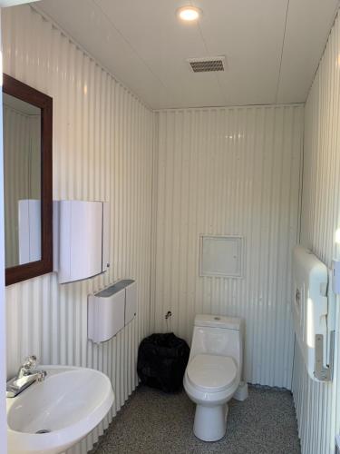 a bathroom with a white toilet and a sink at Centre aéro-récréatif ULM Québec (camping) in Berthierville