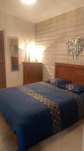 a bedroom with a blue bed with blue pillows at NOUT TI KAZ lé bains in Étang-Salé les Bains