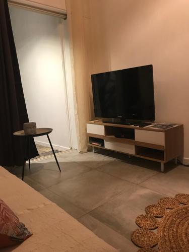 uma sala de estar com uma televisão de ecrã plano num suporte em NOUT TI KAZ lé bains em Étang-Salé les Bains