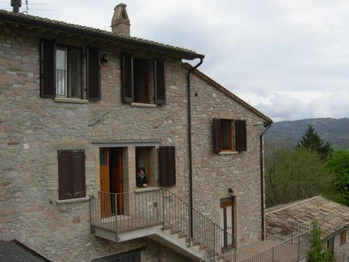 a woman looking out of a window of a building at Casa Vacanze Fortini Mario in Piano Delle Pieve