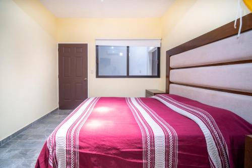 Un dormitorio con una cama grande y una ventana en Casa nueva y moderna en Juchitán, en Juchitán de Zaragoza
