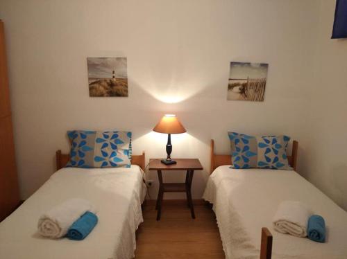 a room with two beds and a table with a lamp at Estevas de Monsaraz in Monsaraz