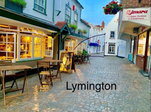 an empty street with tables and chairs in a town at Forest beach Shorefield Park in Lymington