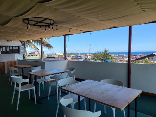 a restaurant with tables and chairs and a view of the ocean at Casa D´Cristhi in Puerto Baquerizo Moreno