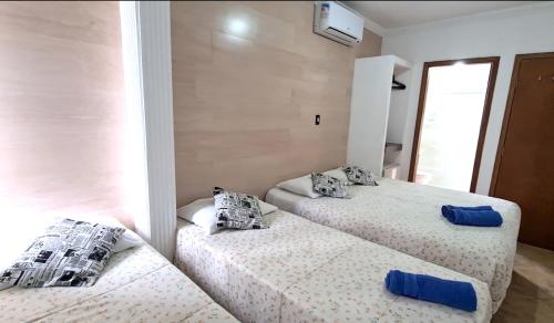 a bedroom with two beds with pillows on them at Hotel Iracemar - Econômico in Guarujá