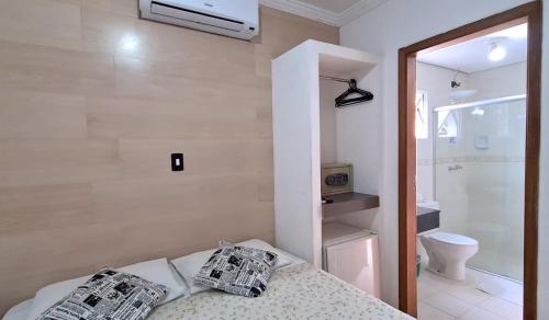 a bathroom with a bed with two newspapers on it at Hotel Iracemar - Econômico in Guarujá
