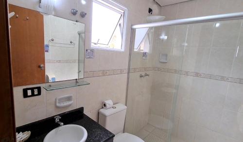 a bathroom with a toilet and a shower and a sink at Hotel Iracemar - Econômico in Guarujá