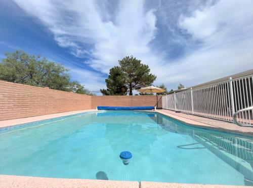 a swimming pool with a fence and blue water at Luxe 4BR 2BTH l Pool & Grill l Central Location l Mountain View l Family Vacation l RV Site in Sierra Vista