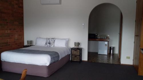 a bedroom with a bed and an arched doorway at Federation Motel Resort - Corowa in Corowa