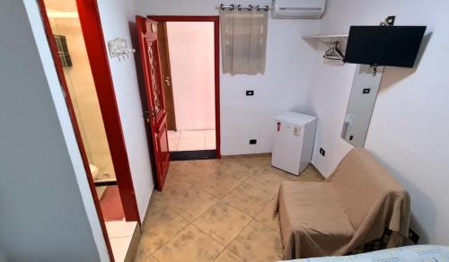 a hallway with a room with a door and a television at Hotel Iracemar - Econômico in Guarujá