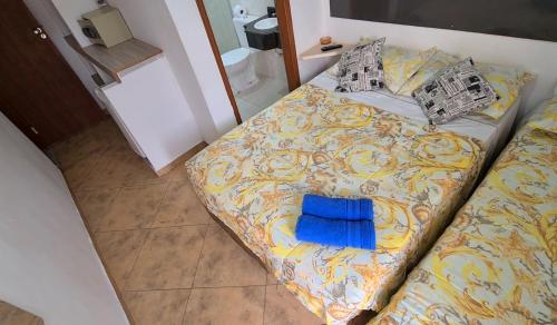 a bed with a blue towel on it in a room at Hotel Iracemar - Econômico in Guarujá