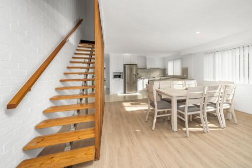a kitchen and dining room with a staircase and a table at Husky 56 Beachfront Villa's - great location on the beach in Huskisson