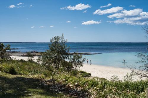 a group of people playing in the water on a beach at Husky 56 Beachfront Villa's - great location on the beach in Huskisson