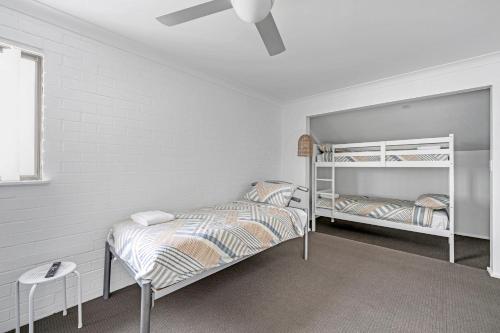 a bedroom with two bunk beds and a ceiling fan at Husky 56 Beachfront Villa's - great location on the beach in Huskisson