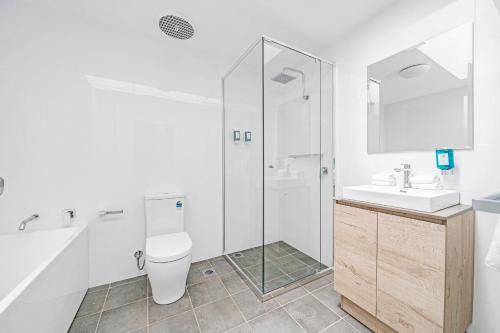a bathroom with a shower and a toilet and a sink at Husky 56 Beachfront Villa's - great location on the beach in Huskisson
