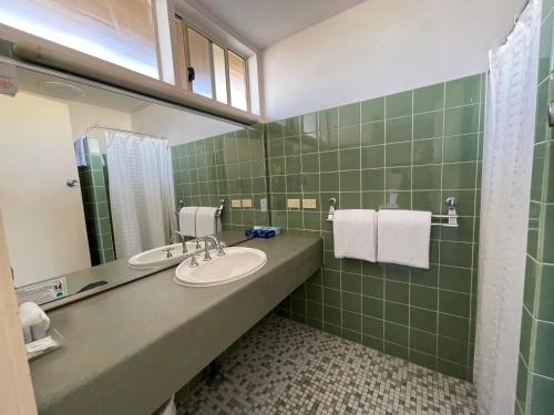 
a bathroom with a sink, toilet, and mirror at Haven Marina Motel in Adelaide
