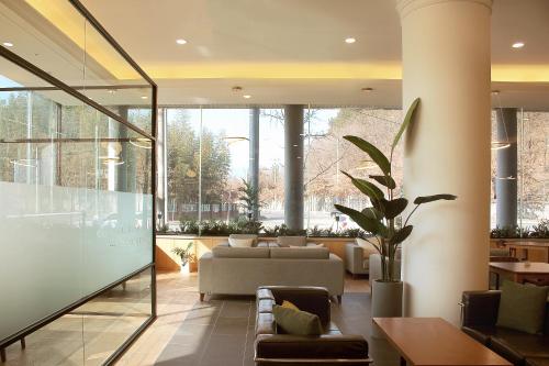 a lobby with a couch and tables and windows at Crown Hotel Changwon in Changwon