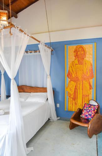 a bedroom with a bed and a painting on the wall at Casa Sol Nascente in Itacaré