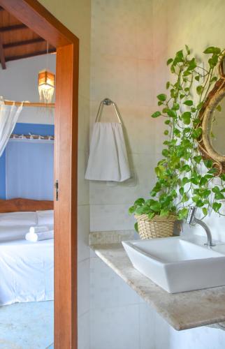 a bathroom with a sink and a bed at Casa Sol Nascente in Itacaré