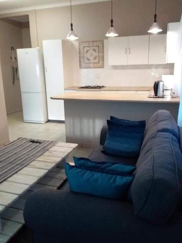 a living room with a blue couch in a kitchen at Sarah's Place Guesthouse in Pretoria