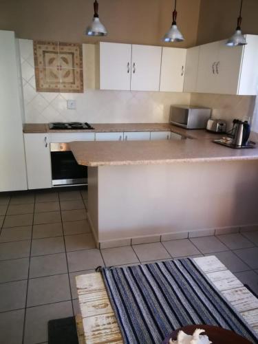a kitchen with white cabinets and a counter top at Sarah's Place Guesthouse in Pretoria
