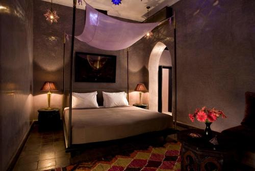a bedroom with a large bed with a canopy at Riad Meriem in Marrakesh