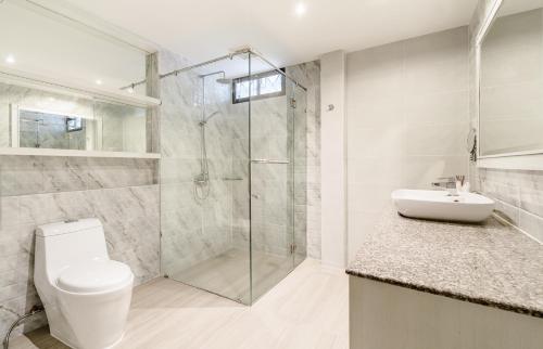 a bathroom with a shower and a toilet and a sink at Villa Pimmada in Ao Nang Beach