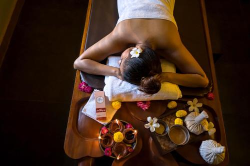 a woman getting a massage in a bath tub at Sarth Ayurveda Retreat and Wellness Centre in Sawantwadi