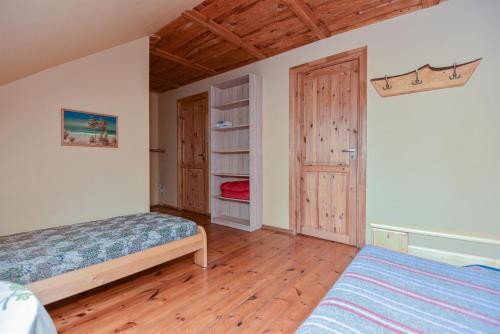 1 dormitorio con 1 cama y suelo de madera en Ozoliņi, en Jūrkalne