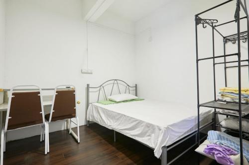 a small room with a bed and a shelf at TheKatil Kuala Lumpur in Kuala Lumpur