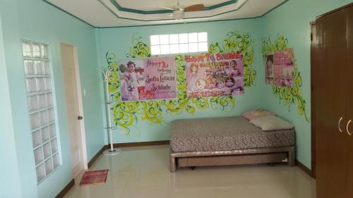 a bedroom with a bed and a wall with posters at Sofias House Rental in Tagbilaran City