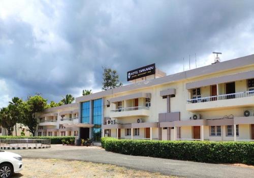 a building with a car parked in front of it at Hotel TamilNadu, Kanniyakumari in Kanyakumari