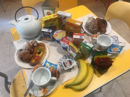 Una mesa con un montón de alimentos para el desayuno y una tetera. en Hotel San Marco, en Pesaro