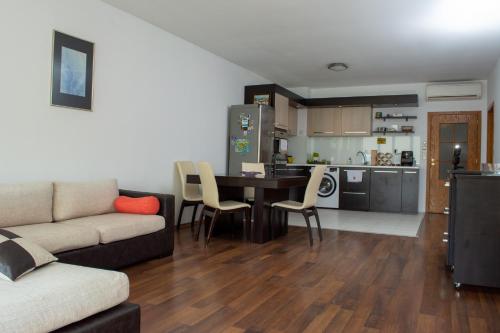 a living room with a couch and a table and a kitchen at Central Apartment Mountain View in Karlovo