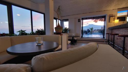 a living room with a couch and a table and windows at Hotel Vello d'Oro in Taormina