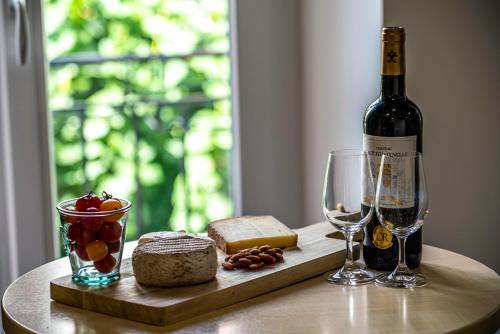 eine Flasche Wein und zwei Gläser auf dem Tisch in der Unterkunft Le Boheme - Rent4night Grenoble in Grenoble