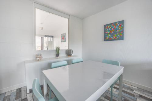 - une salle à manger blanche avec une table et des chaises blanches dans l'établissement Les Sardines, à Courseulles-sur-Mer