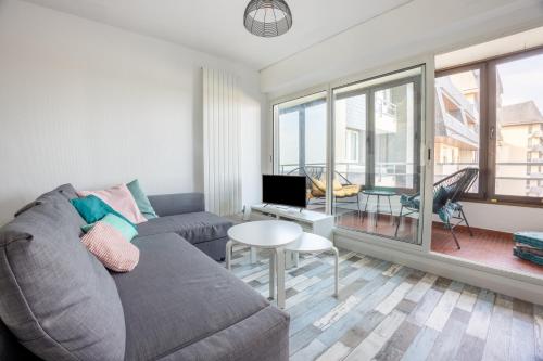 a living room with a couch and a table at Les Sardines in Courseulles-sur-Mer
