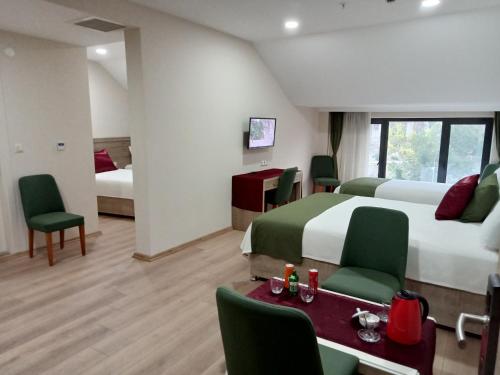a hotel room with two beds and a table and chairs at KURT OTEL in Degirmen