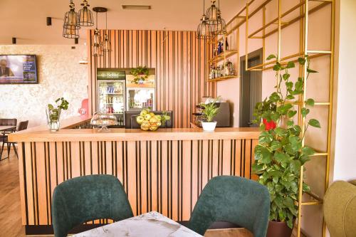 a restaurant with a bar with green chairs at Airport Garden Hotel in Rinas