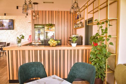 un restaurante con un bar con sillas verdes en Airport Garden Hotel, en Rinas
