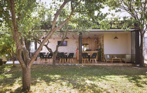 um pátio com cadeiras e mesas num quintal em Airport Garden Hotel em Rinas